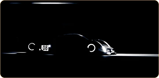 L'image présente la silhouette minimaliste d'une supercar futuriste dans l'obscurité profonde, où seuls ses contours profilés, ses phares et les anneaux lumineux de ses roues sont soulignés d'une lumière blanche éclatante.