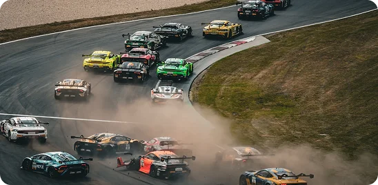 Une scène dynamique de course automobile où un peloton serré de supercars multicolores aborde un virage serré sur le circuit, soulevant un épais nuage de poussière et de graviers dans leur sillage.